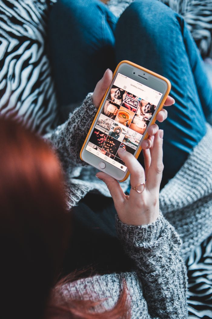 The Art of Drawing Readers In: Your attractive post title goes here Woman scrolling through social media on smartphone, cozy setting.